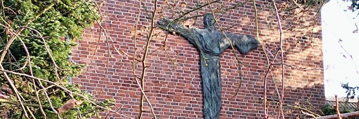 Man sieht die Außenansicht des Klosters mit grüner Wiese