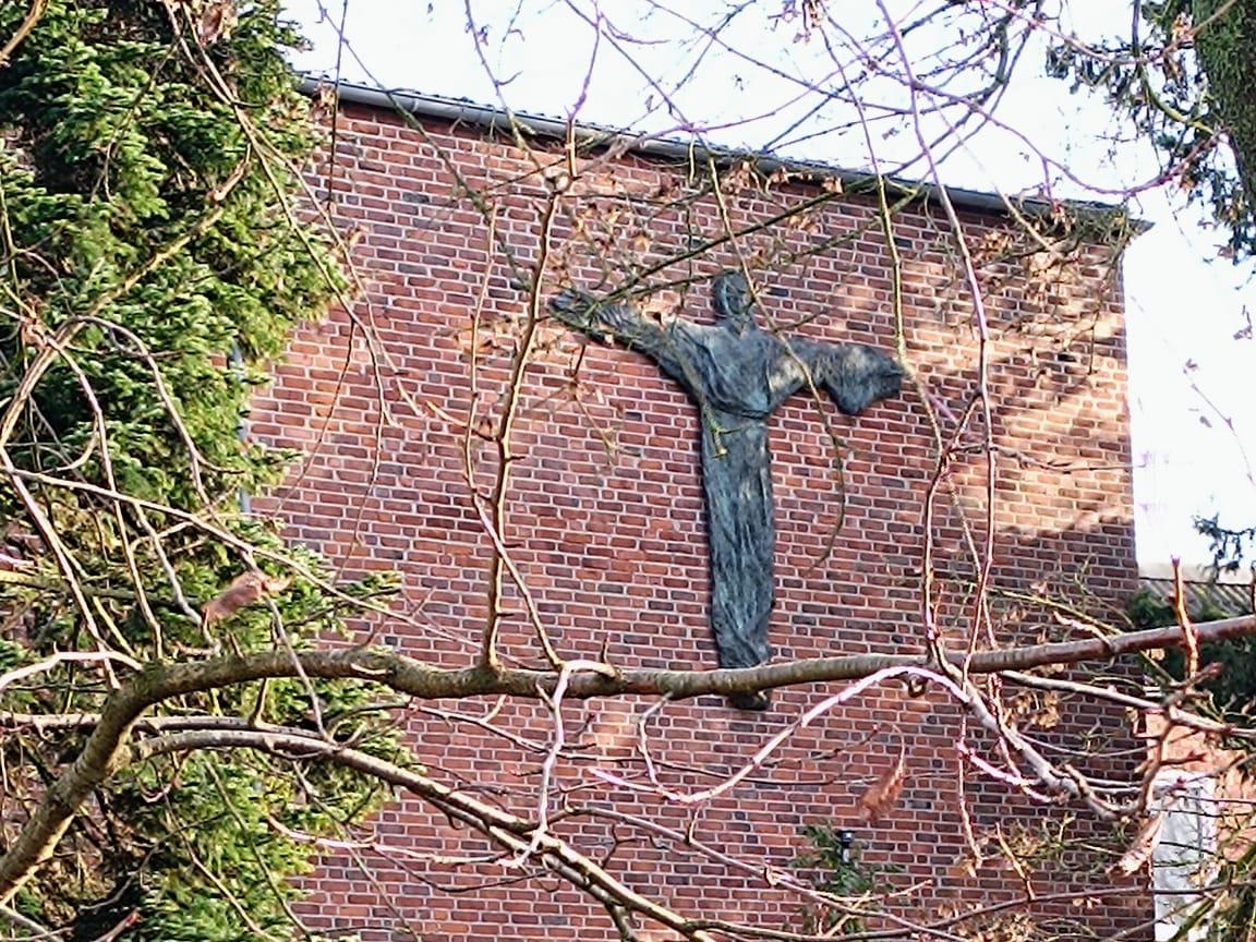 Man sieht die Außenansicht des Klosters mit grüner Wiese
