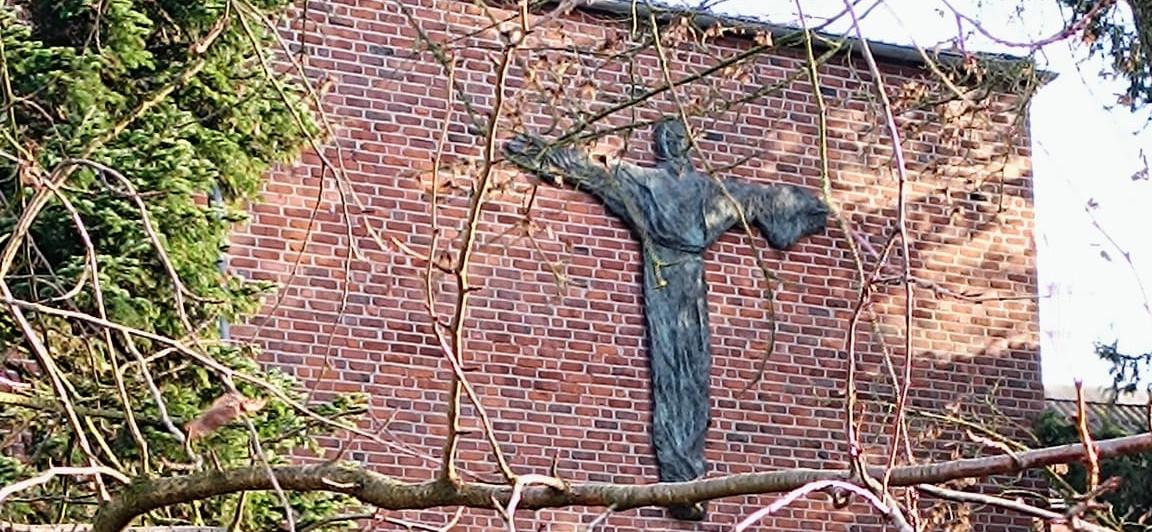 Man sieht die Außenansicht des Klosters mit grüner Wiese