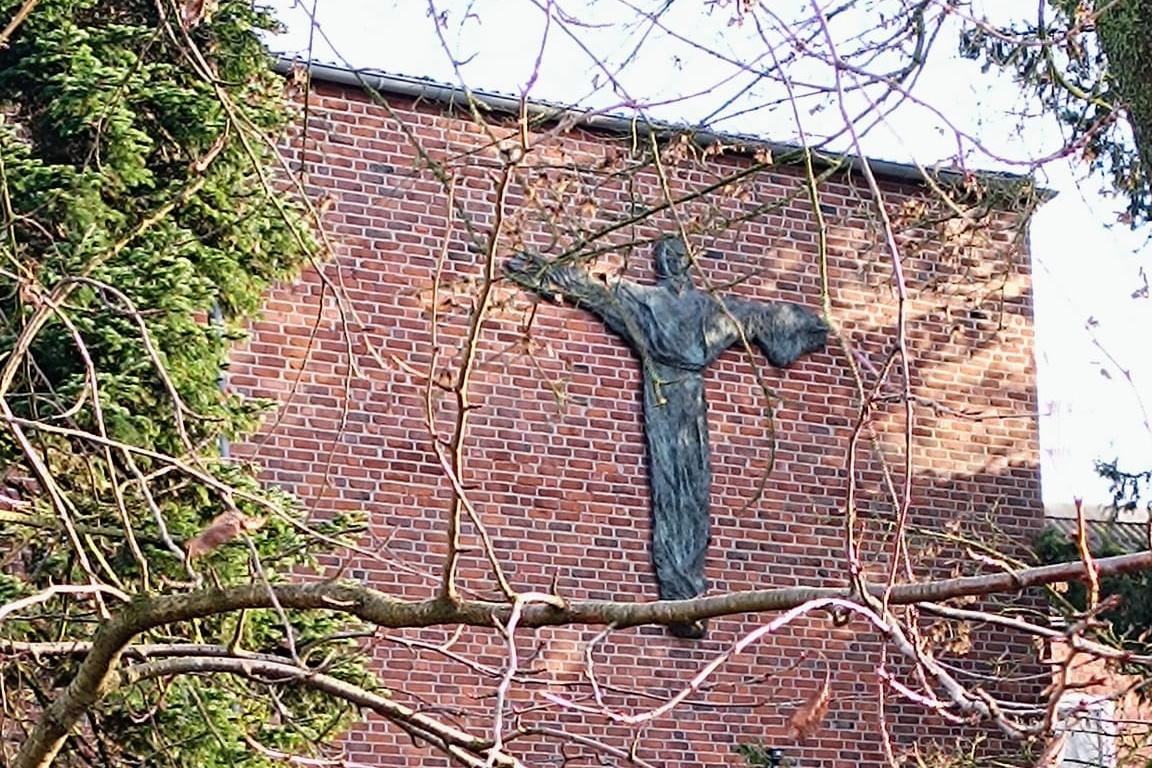 Man sieht die Außenansicht des Klosters mit grüner Wiese