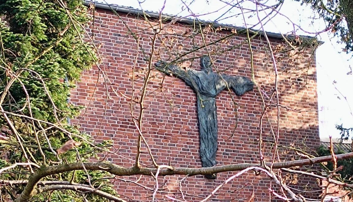 Man sieht die Außenansicht des Klosters mit grüner Wiese