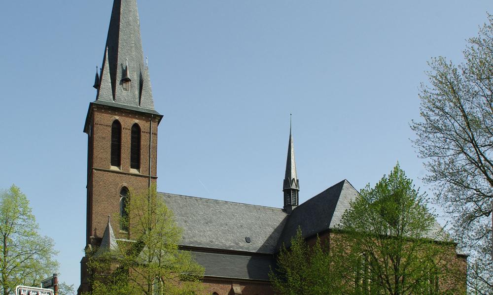 man sieht die Kirche St. Maria unter dem Kreuze von der Seite mit blauem Himmel