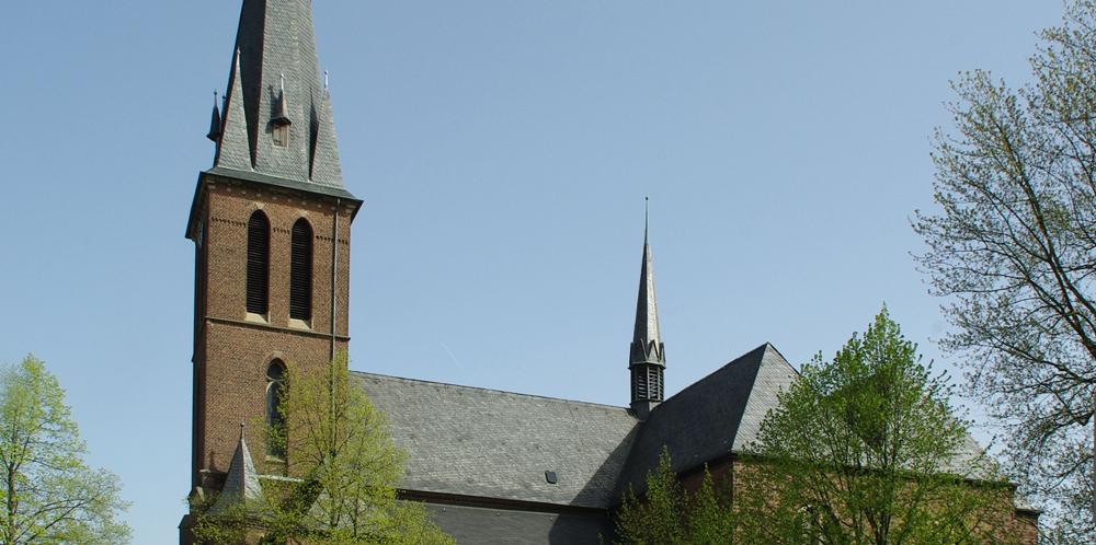 man sieht die Kirche St. Maria unter dem Kreuze von der Seite mit blauem Himmel