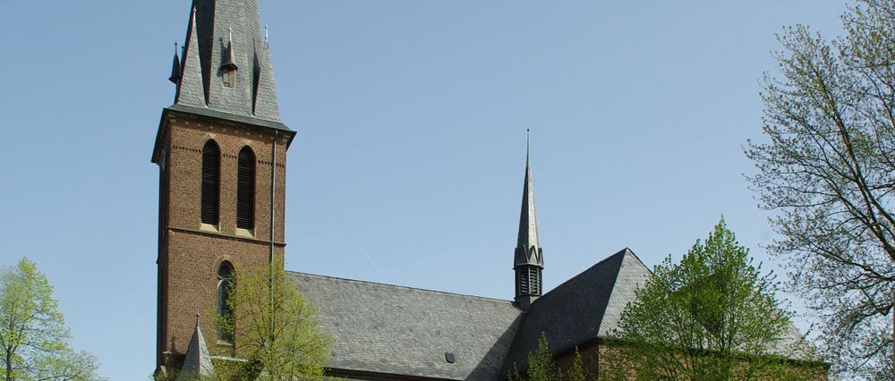 man sieht die Kirche St. Maria unter dem Kreuze von der Seite mit blauem Himmel