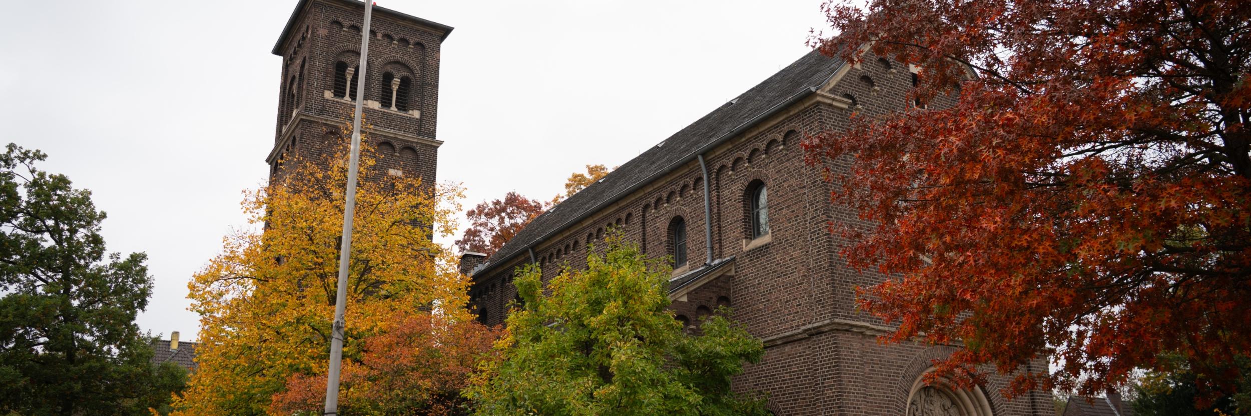 St. Mariä Himmelfahrt von außen vor dem Hauptportal, links an der Seite sieht man den Glockenturm