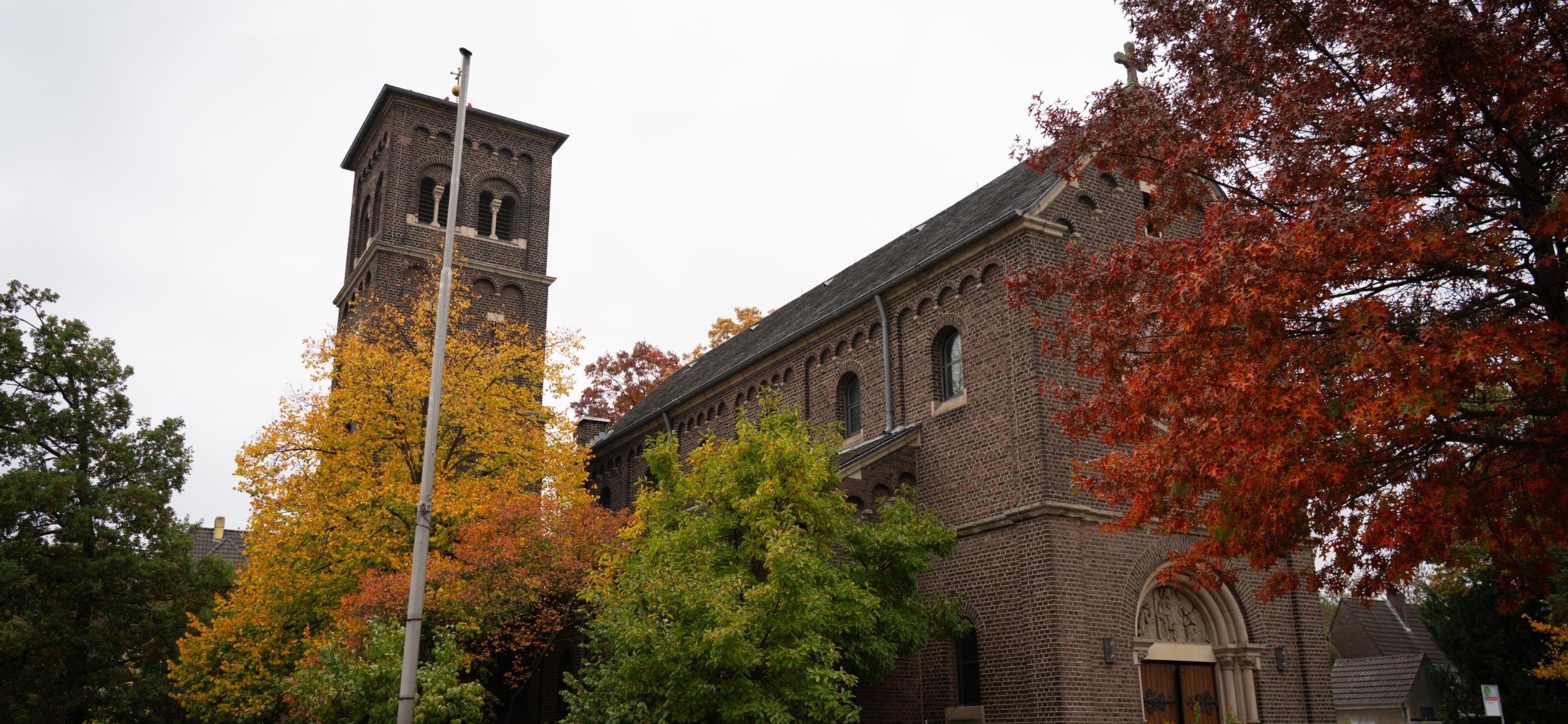 St. Mariä Himmelfahrt von außen vor dem Hauptportal, links an der Seite sieht man den Glockenturm
