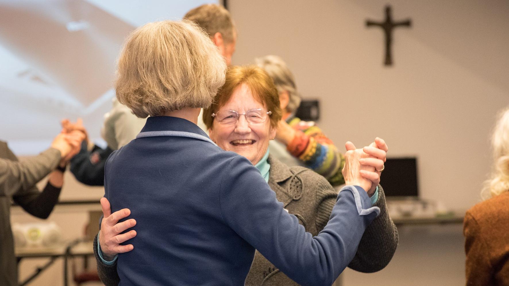 Sie sehen fröhliche tanzende Menschen